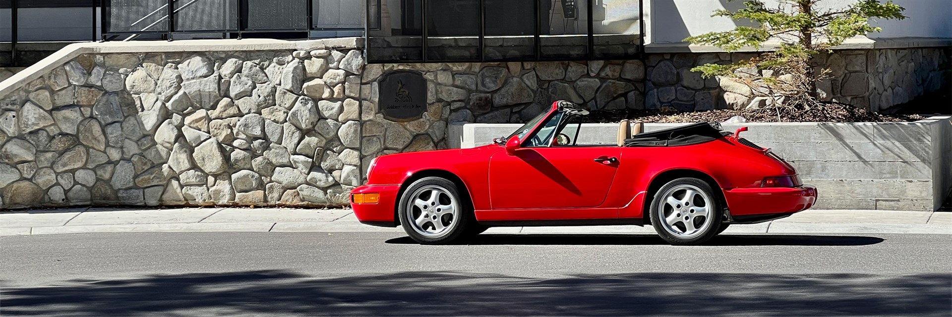 Red Porsche in front of building.