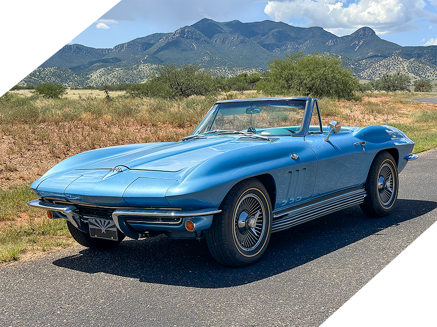 This is an image of a Nassau Blue 1965 Chevrolet Corvette with a white top set against the Huachuca Mountains in Sierra Vista, AZ where Richardson Motor Company is located.